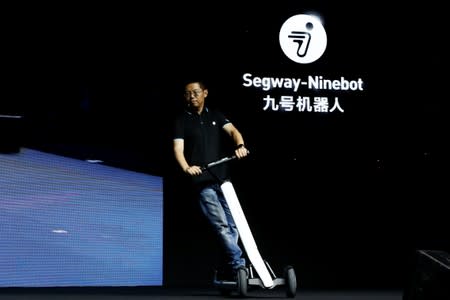 Ninebot President Wang Ye unveils semi-autonomous scooter KickScooter T60 that can return itself to charging stations without a driver, at a Segway-Ninebot product launch event in Beijing