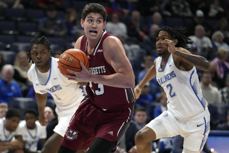 Massachusetts' Josh Cohen drives to the basket in front of Saint Louis' Bradley Ezewiro, left, and Larry Hughes II.