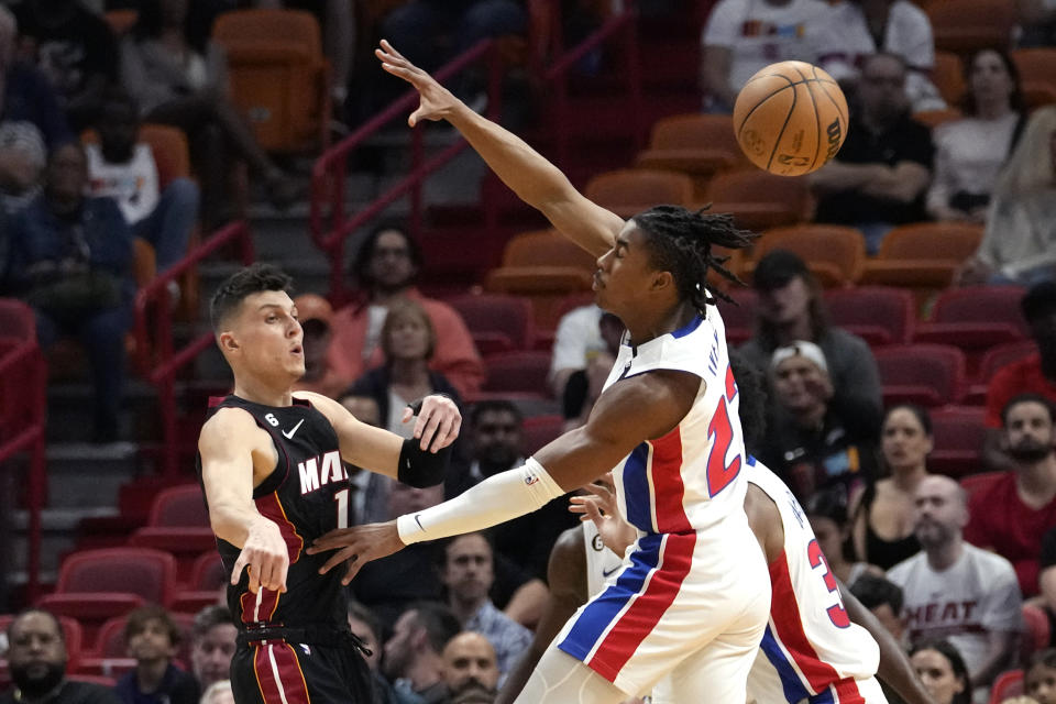 Miami Heat guard Tyler Herro, left, passes the ball as Detroit Pistons guard Jaden Ivey (23) defends during the first half of an NBA basketball game Tuesday, Dec. 6, 2022, in Miami. (AP Photo/Lynne Sladky)