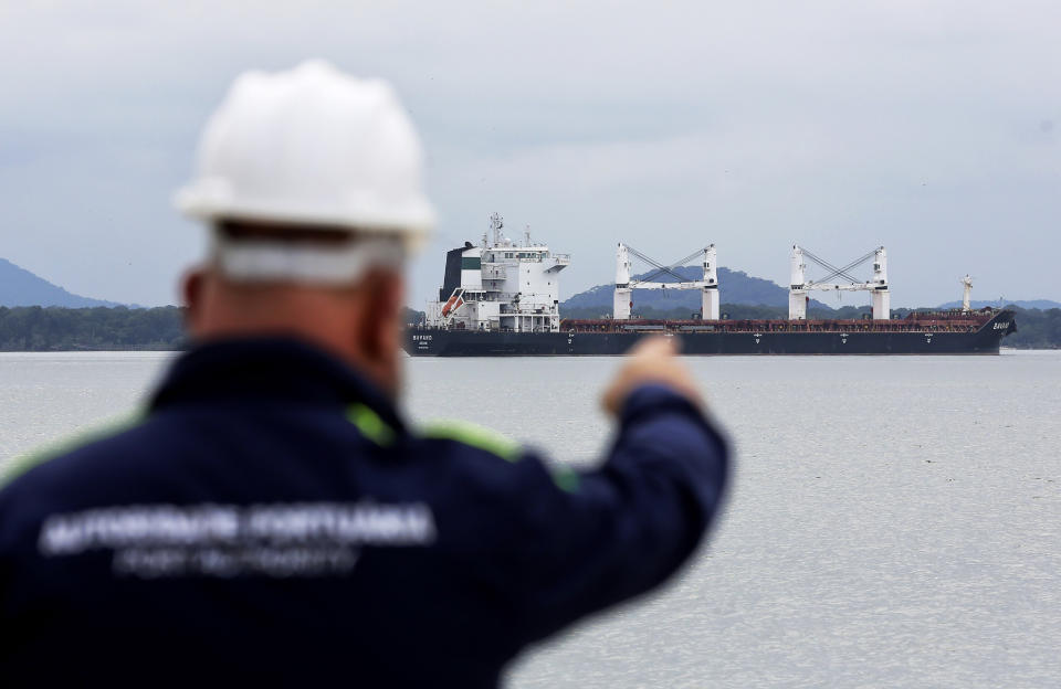 A Port Authority officer points at the Bavand, one of two stranded Iranian vessels, anchored at the port in Paranagua, Brazil, Thursday, July 25, 2019. Brazil's top court says state oil company Petrobras must supply fuel to two Iranian vessels that have been stranded off the coast of Parana state since early June. Petrobras has been refusing to provide fuel to the two vessels, arguing that they appear on a U.S. sanctions list and that the company would risk significant fines. (AP Photo/Giuliano Gomes)