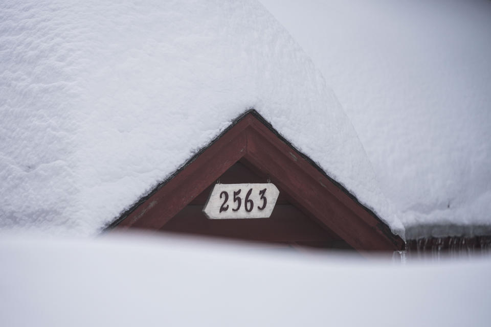 Snow is piled up on a home in Running Springs, Calif., Tuesday, Feb. 28, 2023. Mountainous areas of California experienced nearly unprecedented snowfall accumulations - more than 40 feet since the start of the season. What is going on with all the snow? Meteorologists say the explanation for the robust winter season is not so simple. (AP Photo/Jae C. Hong)