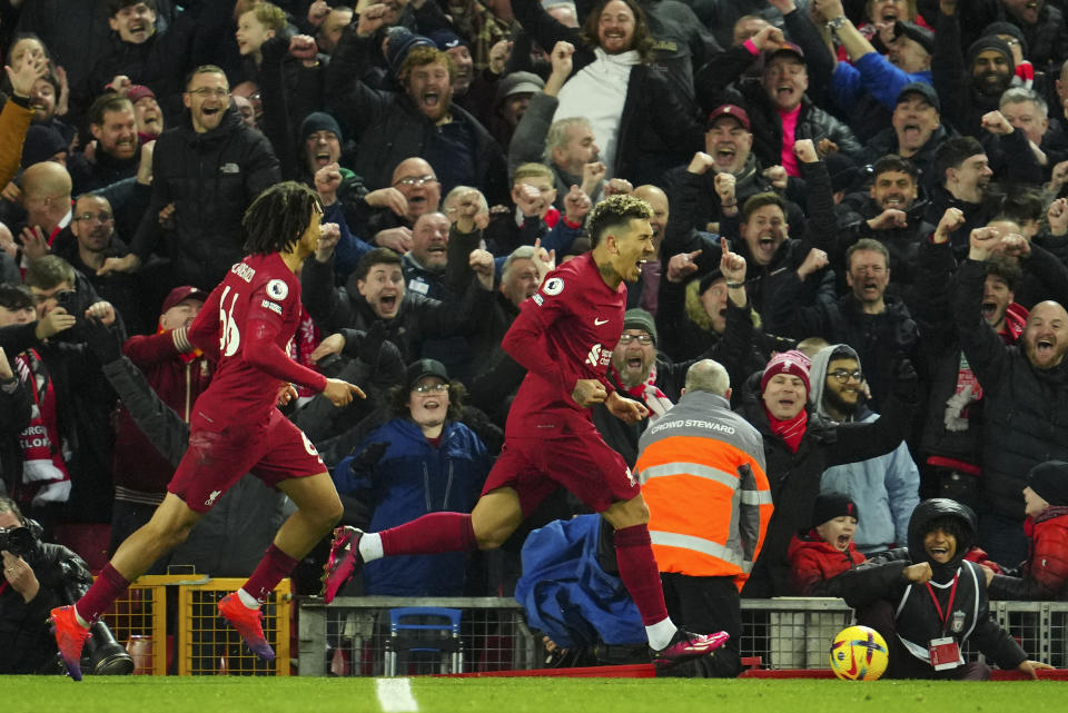 Liverpool's Roberto Firmino, right, celebrates after scoring his side's seventh goal during the English Premier League soccer match between Liverpool and Manchester United at Anfield in Liverpool, England, Sunday, March 5, 2023. (AP Photo/Jon Super)