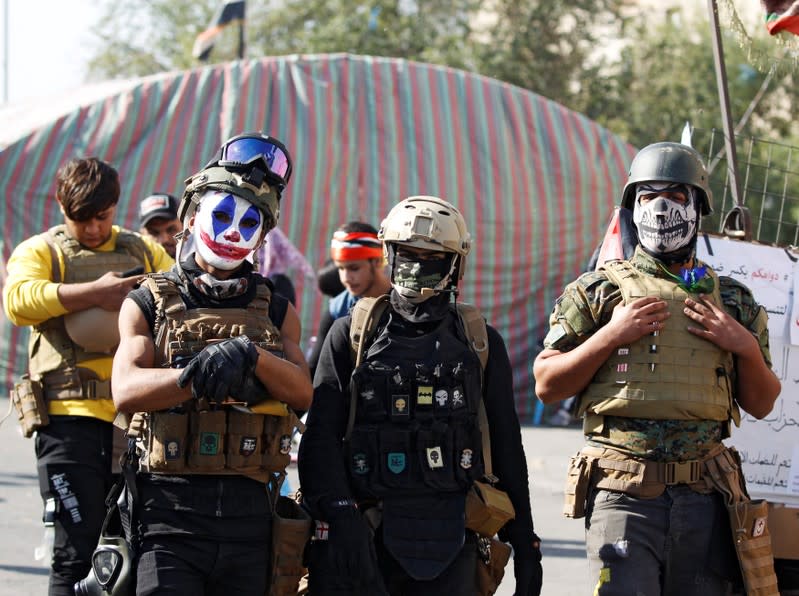 Demonstrators pose for a photo as they take part in ongoing anti-government protests in Baghdad