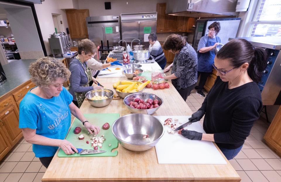 Volunteers work to cut up vegetables for a chicken corn chowder soup Compassion Delivered is preparing at Evermore Church in Lake Township.