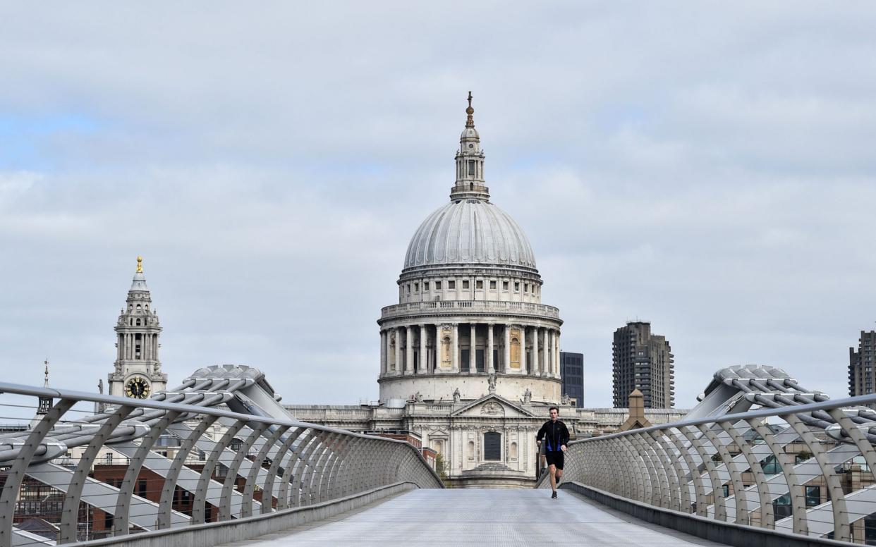 An all but deserted Millennium Bridge, linking the South Bank with St Paul's Cathedral, during the first Covid lockdown last March - Glyn Kirk/AFP