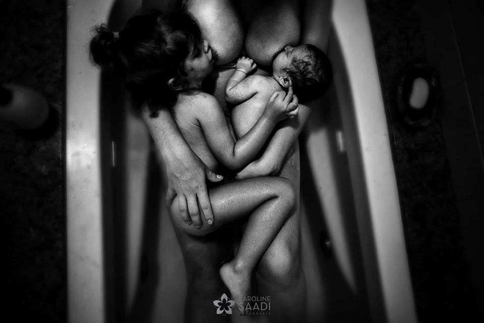 Mother cradling newborn in water for a bonding moment, depicted in a serene and intimate setting