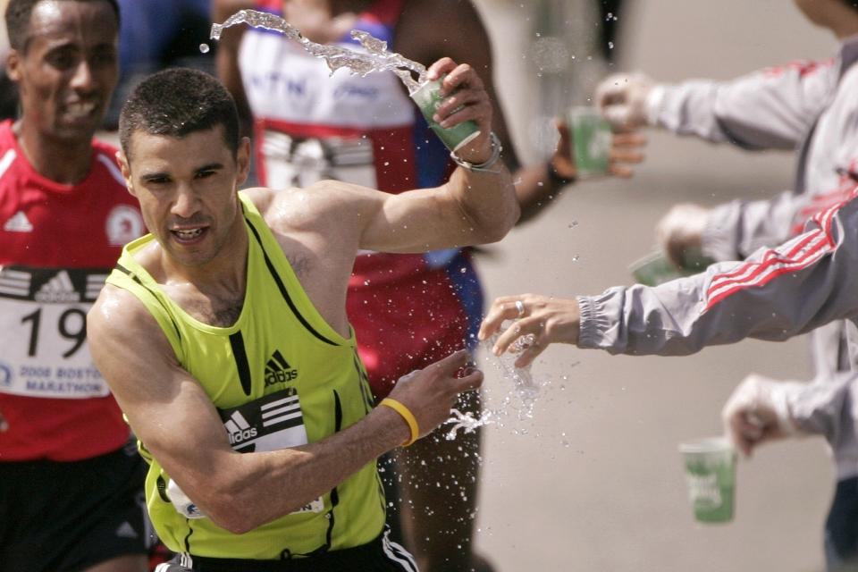 FILE - In this April 21, 2008, file photo, Abderrahime Bouramdane, front, of Morocco, reaches for cups at a water station as Tesfaye Girma, left, of Ethiopia, follows during the Boston Marathon in Wellesley, Mass. Due to the COVID-19 virus pandemic, the 124th running of the Boston Marathon was postponed from its traditional third Monday in April to Monday, Sept. 14, 2020. (AP Photo/Steven Senne, File)