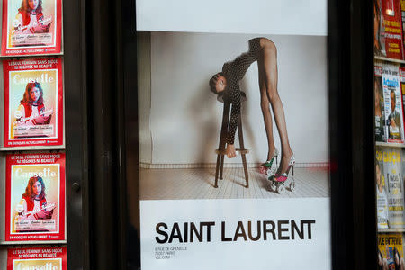 An ad by French fashion house Yves Saint Laurent is seen on a newspaper kiosk in Paris, France, March 6, 2017. France's advertising watchdog on Monday said it had asked French fashion house Yves Saint Laurent to modify two ads from its latest campaign after receiving 50 complaints that they were "degrading" to women. REUTERS/Charles Platiau