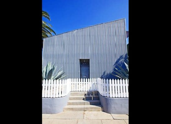 The classic white picket fence is a nod to tradition in front of Hopper's asymmetrical, metal-clad abode.