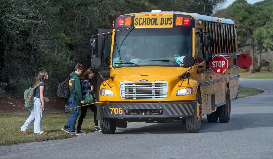 High school students board a Santa Rosa County School bus in the Tiger Point area on Thursday, March 7, 2024. The Santa Rosa County School District has equipped its bus fleet with stop arm cameras to record drivers passing district buses during the unloading and loading of passengers.