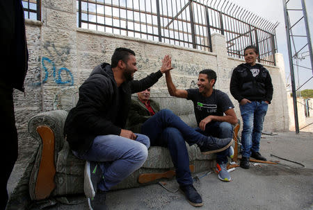 Nuseir Yassin holds the hand of a Palestinian man as he is filmed in Aida refugee camp in the West Bank city of Bethlehem March 2, 2017. REUTERS/Mussa Qawasma