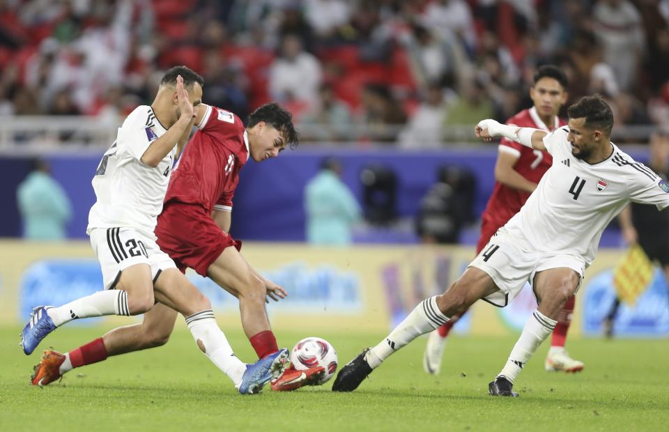 Indonesia's Rafael William Struick, middle, fights for the ball with Iraq's Suad Natiq Naji during the Asian Cup Group D soccer match between Indonesia and Iraq at Ahmad Bin Ali Stadium in Al Rayyan, Qatar, Monday, Jan. 15, 2024. (AP Photo/Hussein Sayed)