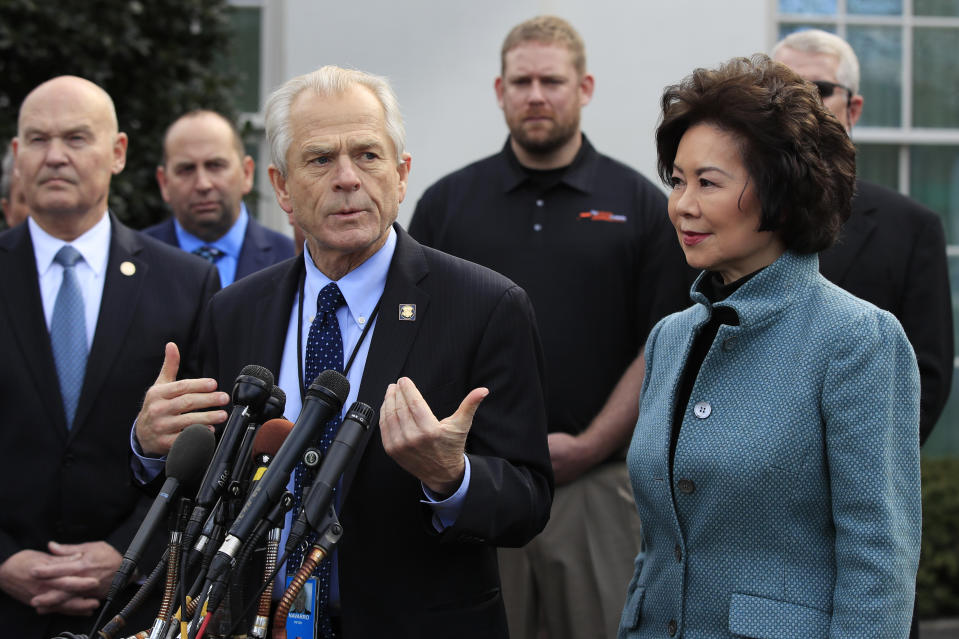 FILE - In this March 4, 2019, file photo, White House trade adviser Peter Navarro, front left, with Transportation Secretary Elaine Chao, right, and U.S. Maritime Administration Administrator Mark Buzby, back left, speaks to reporters outside the West Wing of the White House in Washington. Where past presidents have relied on top academics, business leaders and officials with experience in prior administrations, Trump has gone a different route. He’s built crew of camera-ready economic advisers, rather than one known for its policy chops. (AP Photo/Manuel Balce Ceneta, File)