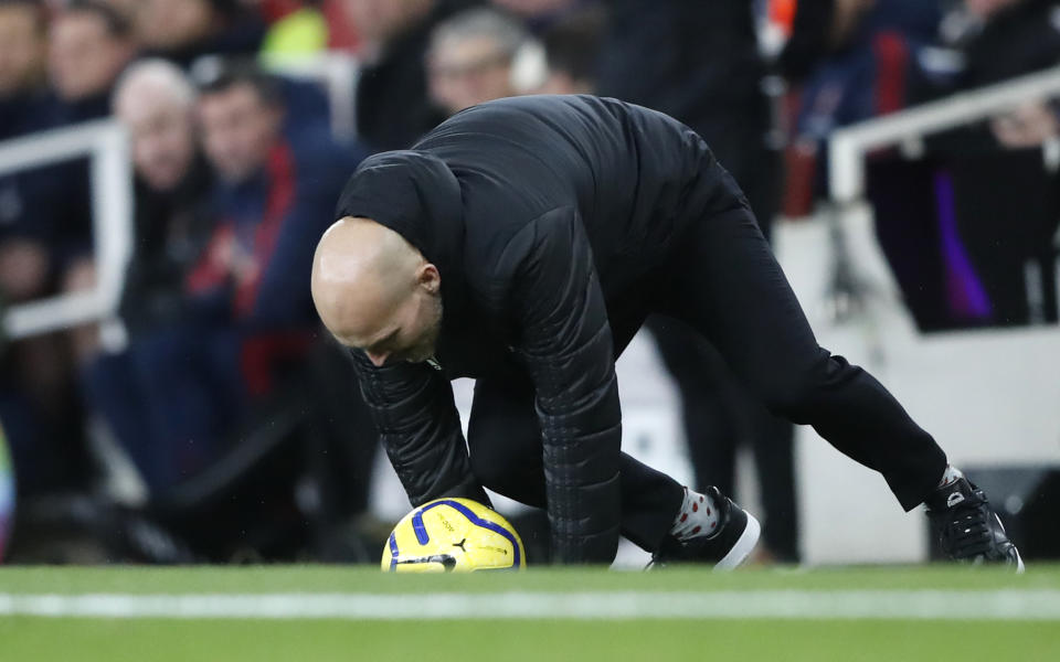 Arsenal's interim head coach Freddie Ljungberg slips as he catches the ball during the English Premier League soccer match between Arsenal and Brighton, at the Emirates Stadium in London, Thursday, Dec. 5, 2019. (AP Photo/Frank Augstein)