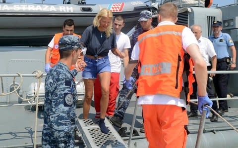 Kay Longstaff is escorted by rescuers from a Croatian Coast Guard vessel in the port of Pula - Credit: AP