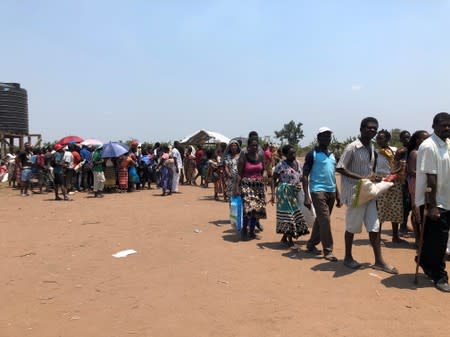 People queue at an aid distribution for Cyclone Idai victims at a camp in Guara Guara