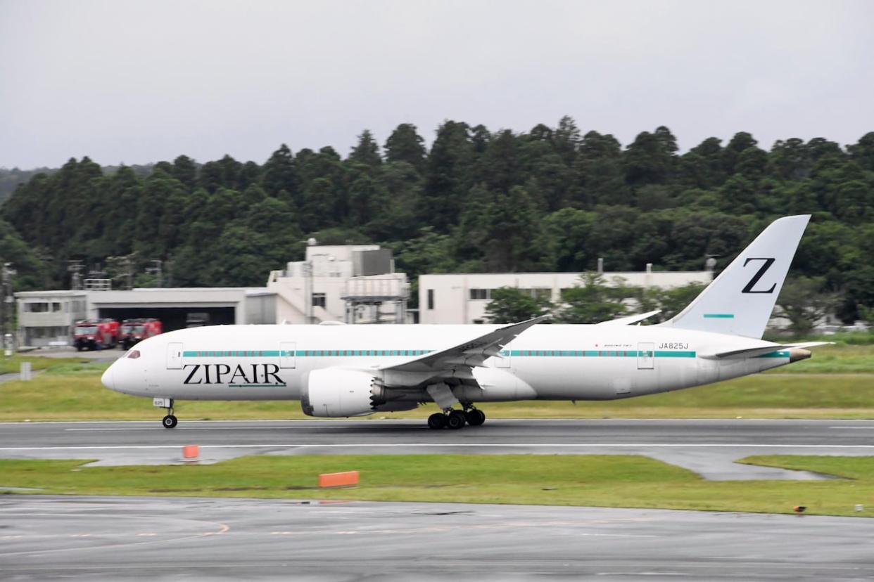 This photo shows an airplane of Japanese low-cost carrier Zipair at Narita Airport near Tokyo. The budget airline is offering a Vancouver to Tokyo flight that a tourism expert says may set a high bar for other carriers. (Kyodo News via The Associated Press - image credit)