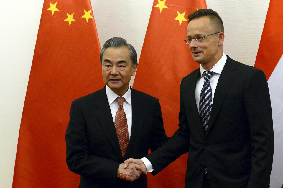 Chinese Foreign Minister Wang Yi, left, shakes hands with Hungarian Minister of Foreign Affairs and Trade Peter Szijjarto during their meeting in the latter's office in Budapest, Hungary, Friday, July 12, 2019. (Lajos Soos/MTI via AP)