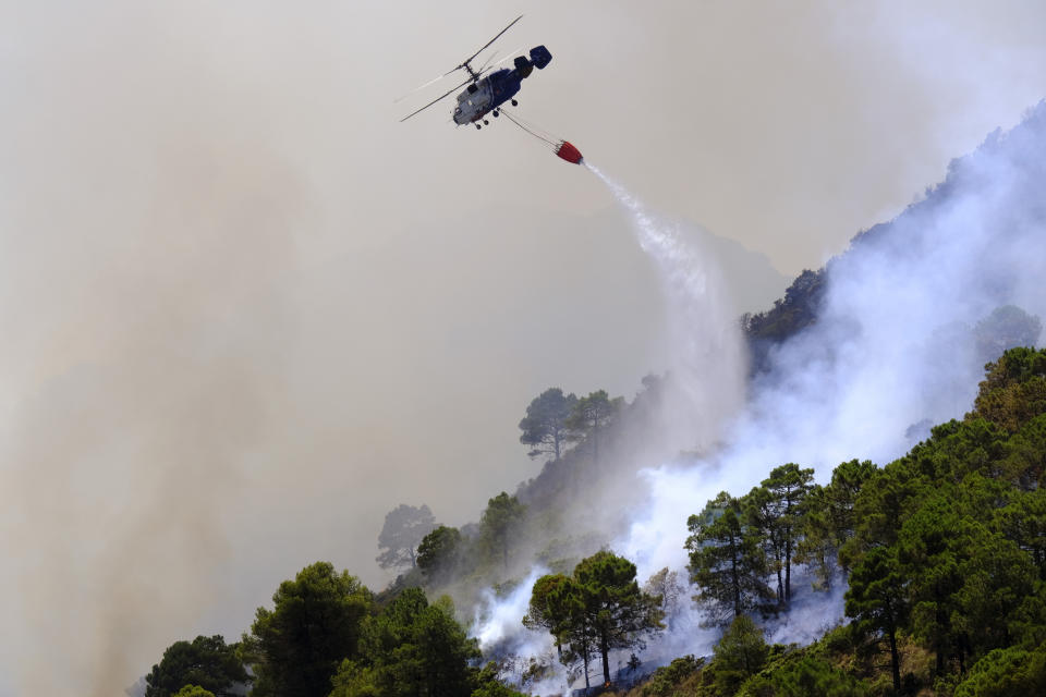 FILE - A helicopter launches water as a wildfire advances near a residential area in Alhaurin de la Torre, Malaga, Spain, July 16, 2022. Major wildfires in Europe are starting earlier in the year, becoming more frequent, doing more damage and getting harder to stop. And, scientists say, they’re probably going to get worse as climate change intensifies unless countermeasures are taken. (AP Photo/Gregorio Marrero, File)