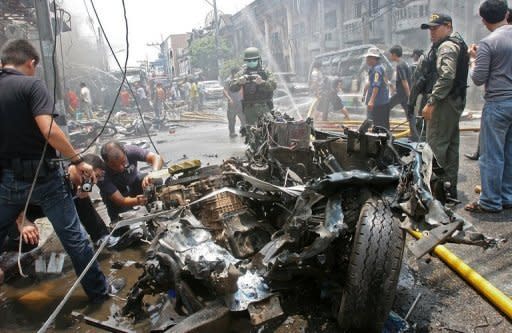 Thai bomb squad members inspect the wreckage of a car at the scene of a car bomb blast in Thailand's southern restive province of Yala. Three bomb attacks minutes apart killed 10 people and wounded more than 100 in the main town in Thailand's insurgency-hit far south