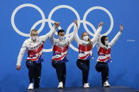 Britain mixed 4x100-meter medley relay team, from left, Adam Peaty, James Guy Anna Hopkin and Kathleen Dawson, step onto the podium after winning the gold medal at the 2020 Summer Olympics, Saturday, July 31, 2021, in Tokyo, Japan. (AP Photo/Gregory Bull)