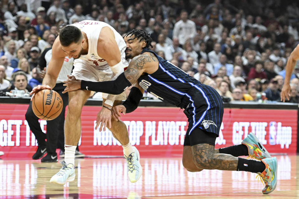 Cleveland Cavaliers' Max Strus, left, steals the ball from Orlando Magic's Gary Harris during the first half in Game 1 of an NBA basketball first-round playoff series, Saturday, April 20, 2024, in Cleveland. (AP Photo/Nick Cammett)