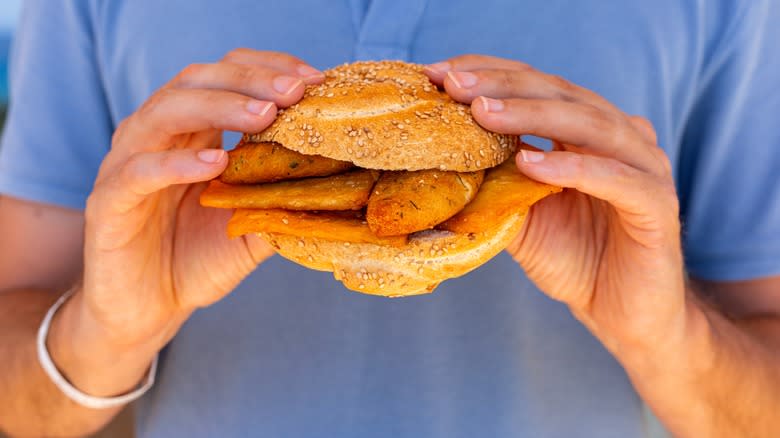 man holding panelle sandwich