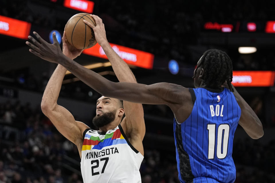 Minnesota Timberwolves center Rudy Gobert (27) shoots while defended by Orlando Magic center Bol Bol (10) during the first half of an NBA basketball game, Friday, Feb. 3, 2023, in Minneapolis. (AP Photo/Abbie Parr)