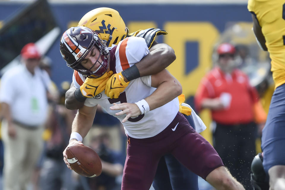 Virginia Tech quarterback Braxton Burmeister (3) is sacked by West Virginia linebacker Jared Bartlett (10) during the second half of an NCAA college football game in Morgantown, W.Va., Saturday, Sep. 18, 2021. (AP Photo/William Wotring)