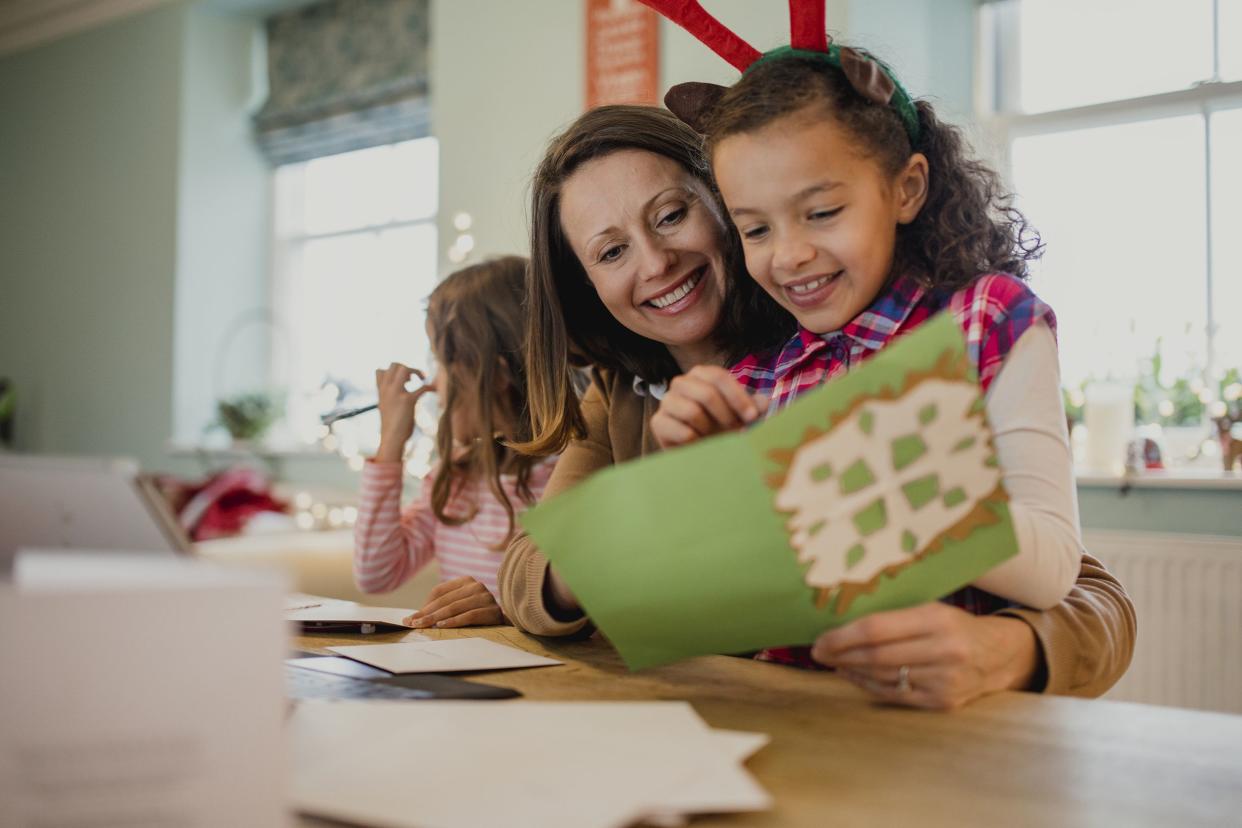 mom and two young daughters making Christmas cards