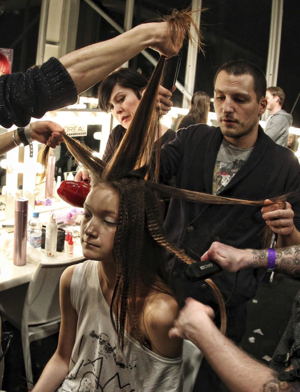 A model gets her hair prepared before the Marios Schwab Autumn/Winter London Fashion Week 2013 fashion show at the Courtyard space in Somerset House, London, Sunday Feb. 17, 2013. (AP Photo / Lewis Whyld, PA) UNITED KINGDOM OUT - NO SALES - NO ARCHIVES