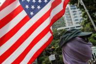 A student protester holds a U.S. flag near the Goddess of Democracy statue before the start of a student march on the campus of the Chinese University of Hong Kong