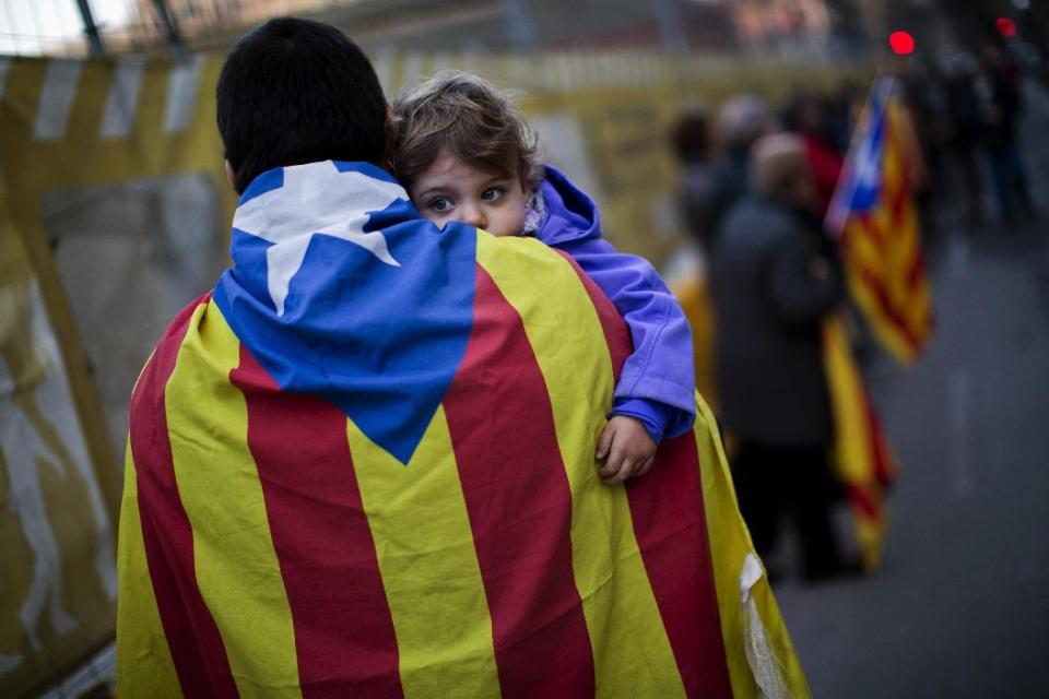 EDS NOTE - SPANISH LAW REQUIRES THAT THE FACES OF MINORS ARE MASKED IN PUBLICATIONS WITHIN SPAIN In this photo taken on Sunday, Jan. 12, 2014, a man wearing an "estelada" flag holds her daughter during a pro-independence event in Barcelona, Spain. After years of mass protests by Catalans demanding the right to decide whether they want to break away from Spain and form a new European nation, the wealthy northeastern region’s lawmakers vote to ask permission from Spanish authorities to hold a secession referendum in November. The request eight months ahead of a Scottish independence referendum is certain to be denied by the central government in Madrid but is virtually guaranteed of generating even more separatist fervor. (AP Photo/Emilio Morenatti)