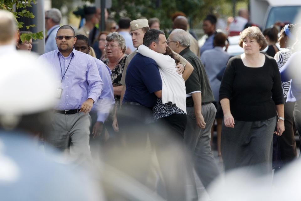 Navy Yard workers evacuated after the shooting are reunited with loved ones at a makeshift Red Cross shelter at the Nationals Park baseball stadium near the affected naval installation in Washington, September 16, 2013. (REUTERS/Jonathan Ernst)