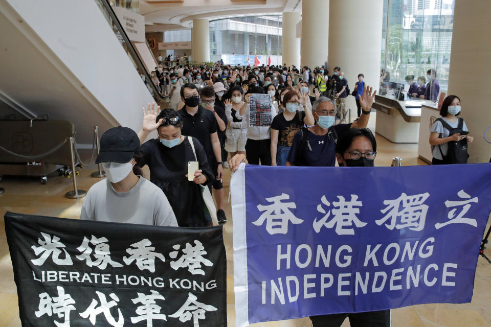 Protesters hold flags in a shopping mall during a protest in Hong Kong, Friday, June 12, 2020. Protesters in Hong Kong got its government to withdraw extradition legislation last year, but now they're getting a more dreaded national security law. And the message from Beijing is that protest is futile. (AP Photo/Kin Cheung)