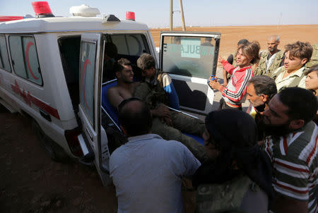 Rebel fighters move an injured fellow member into an ambulance, after bringing him from the Guzhe frontline, near Guzhe village, northern Aleppo countryside, Syria October 17, 2016. REUTERS/Khalil Ashawi