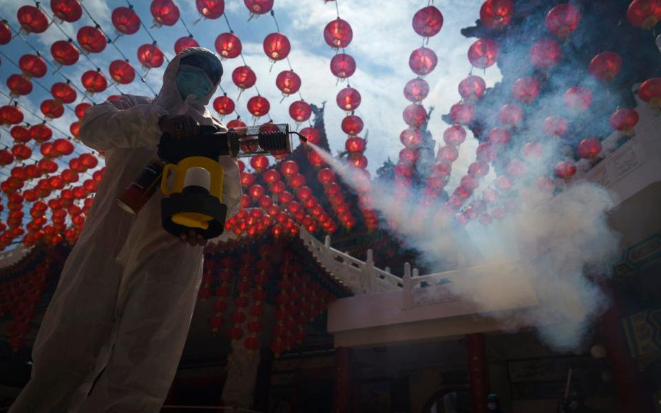 A worker disinfects the Thean Hou Temple during during first day of Chinese Lunar New Year celebrations. A movement control order (MCO) currently enforced across the country to help curb the spread of the coronavirus has been extended to Feb. 18 - effectively covering the Chinese New Year festival that falls on Feb. 12 this year. - AP Photo/Vincent Thian