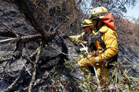 Firefighters use an axe to extinguish hotspots during the Soberanes Fire in the mountains above Carmel Highlands, California, U.S. July 28, 2016. REUTERS/Michael Fiala