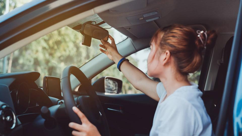 Safety driving woman adjust the car rearview mirror in interior before start travel trip every time.