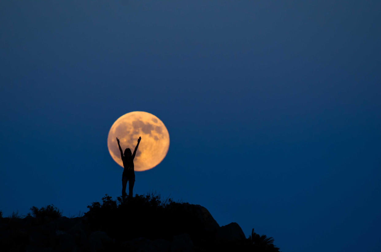 Woman silhouette on the full moon (Manuel Breva Colmeiro / Getty Images)