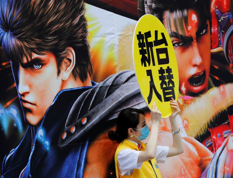 A woman wearing a protective face mask attracts customers on the street amid the coronavirus disease (COVID-19) outbreak, in Tokyo