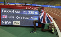 FILE - Britain's Mo Farah poses next to the board after setting a world record during the One Hour Men at the Diamond League Memorial Van Damme athletics event at the King Baudouin stadium in Brussels on Friday, Sept. 4, 2020. It is hard to be first. Mo Farah this week went from being a gold medal-winning runner to the most prominent person ever to come forward as a victim of people trafficking. The four-time Olympic champion’s decision to tell the story of how he was exploited as a child gives a face to the often faceless victims of modern slavery, highlighting a crime that is often conflated with illegal immigration. (AP Photo/Virginia Mayo, File)