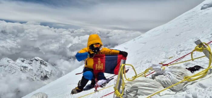 Climber holding flag on a summit.