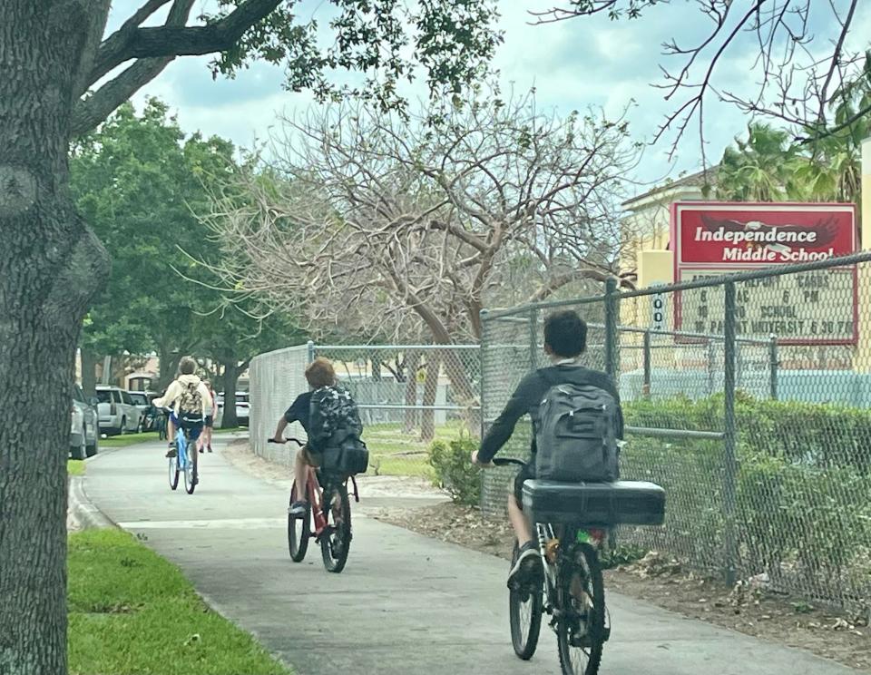 Independence Middle School students bike home in Jupiter, Fla., on April 11, 2024.