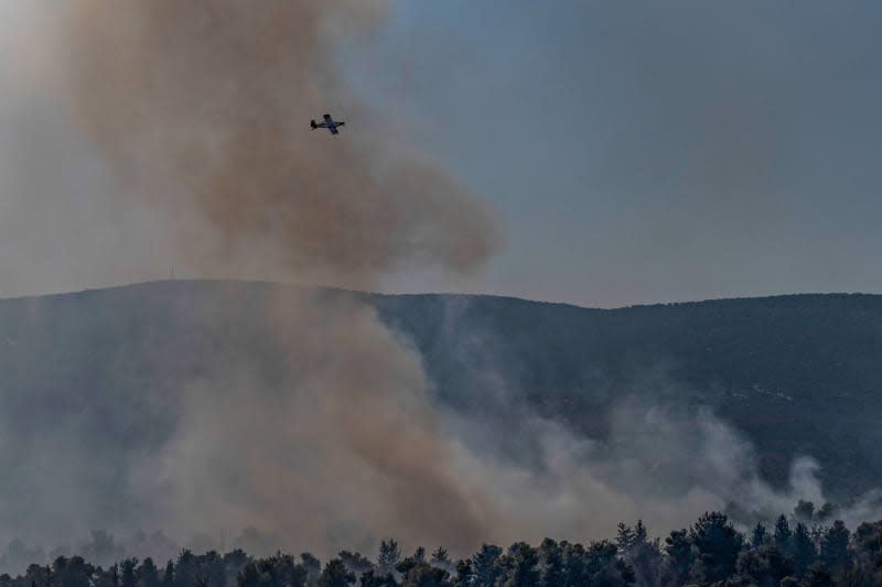 A fire-fighting plane tries to extinguish a fire that erupts in a forest following a rocket hit from Lebanon on Safed. Ilia Yefimovich/dpa