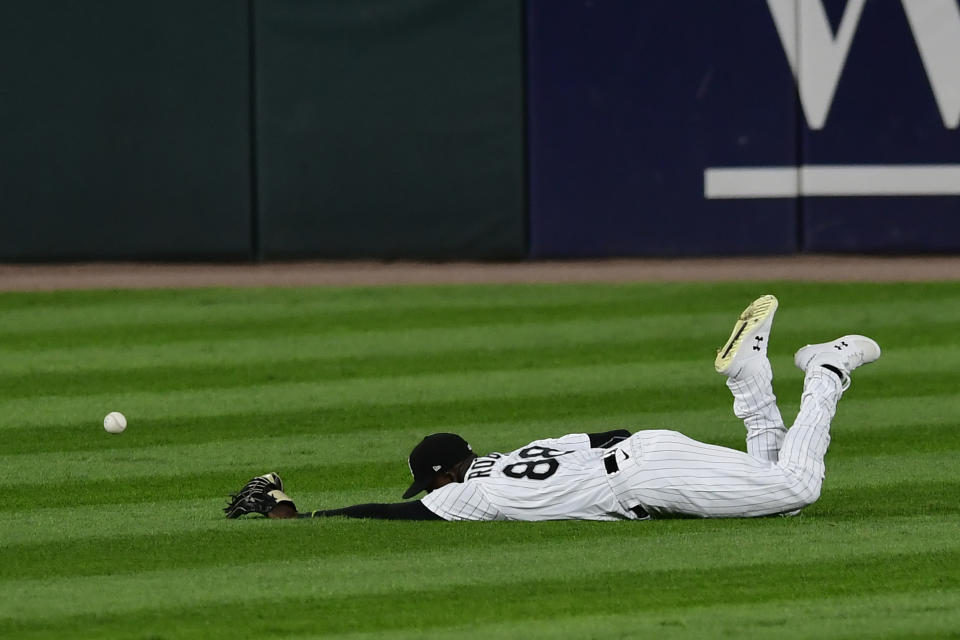 Chicago White Sox center fielder Luis Robert misses a single hit by Detroit Tigers' Austin Romine during the seventh inning of a baseball game Sox Tuesday, Aug. 18, 2020, in Chicago. (AP Photo/Paul Beaty)