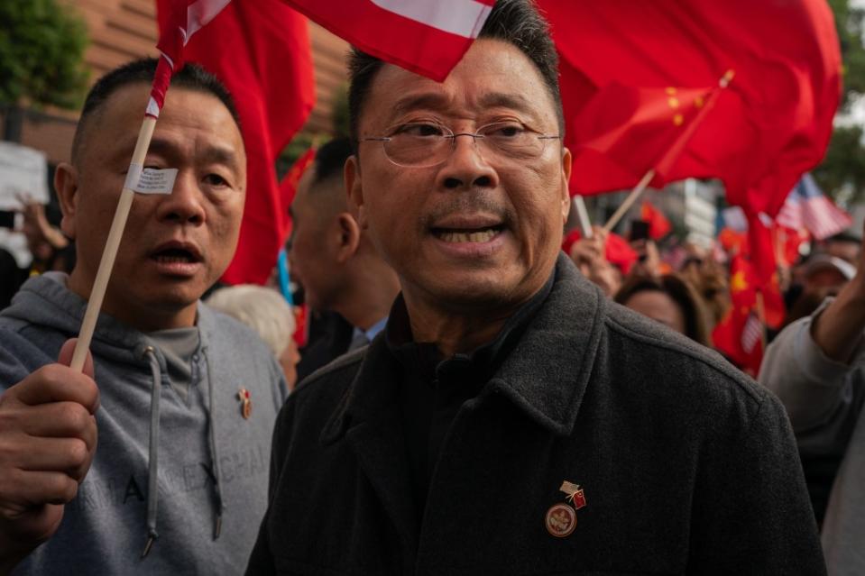 Supporters of Xi Jinping wore buttons emblazoned with the logo of one of John Chan’s New York nonprofits that support the Chinese Communist Party at a demonstration during the November APEC summit in San Francisco. Jungho Kim