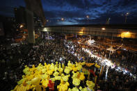 Inflatable yellow ducks, which have become good-humored symbols of resistance during anti-government rallies, are lifted over a crowd of protesters Friday, Nov. 27, 2020 in Bangkok, Thailand. Pro-democracy demonstrators are continuing their protests calling for the government to step down and reforms to the constitution and the monarchy, despite legal charges being filed against them and the possibility of violence from their opponents or a military crackdown. (AP Photo/Sakchai Lalit)