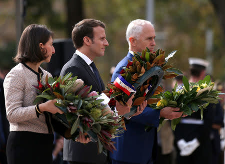 (L-R) NSW Premier Gladys Berejiklian, French President Emmanuel Macron and Australian Prime Minister Malcolm Turnbull place wreaths during a Commemorative Service at the Anzac war memorial in Sydney, May 2, 2018. AAP/Rick Rycroft/Pool via REUTERS