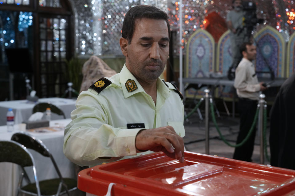 A policeman casts his vote for the presidential election in a polling station at the shrine of Saint Saleh in northern Tehran, Iran, Friday, July 5, 2024. Iran held a runoff presidential election on Friday that pitted a hard-line former nuclear negotiator against a reformist lawmaker. (AP Photo/Vahid Salemi)